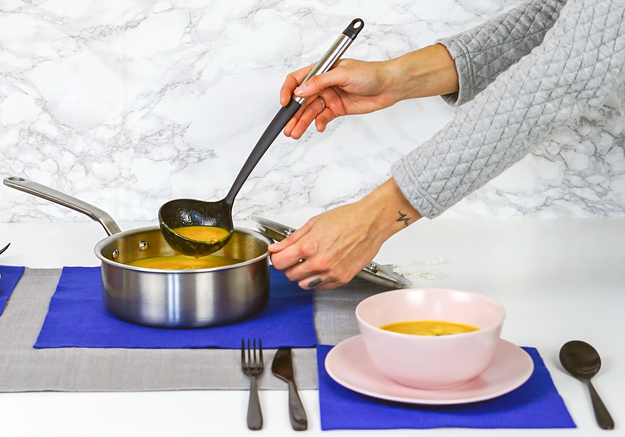 woman ladling soup from a pot