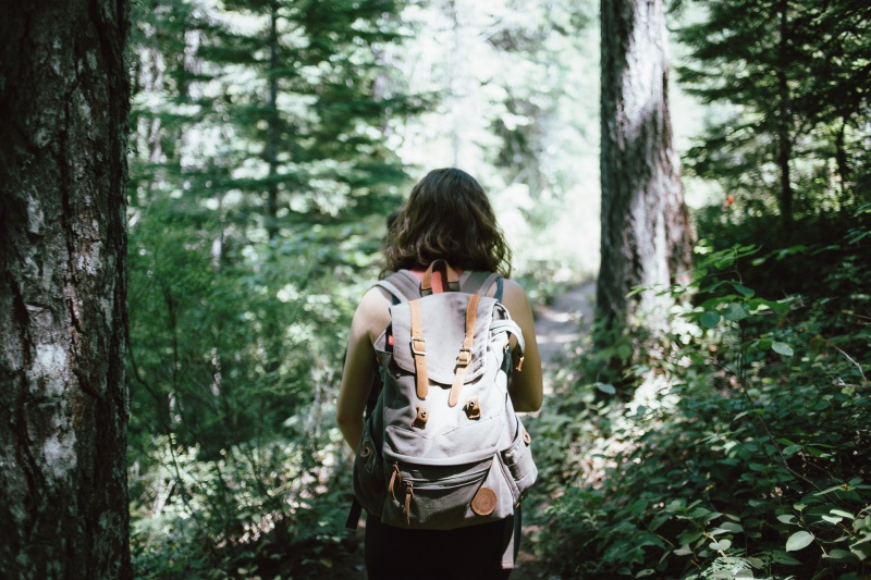 woman with a backpack on a hiking trail in the woods