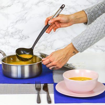 woman ladling soup from a pot