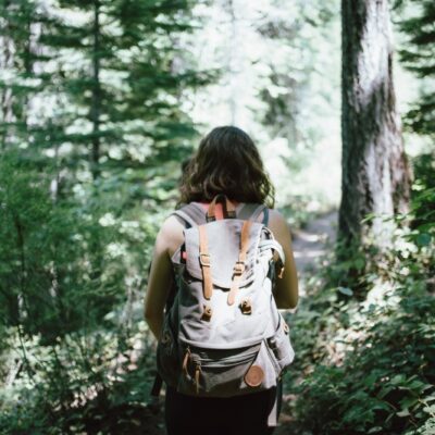 woman with a backpack on a hiking trail in the woods