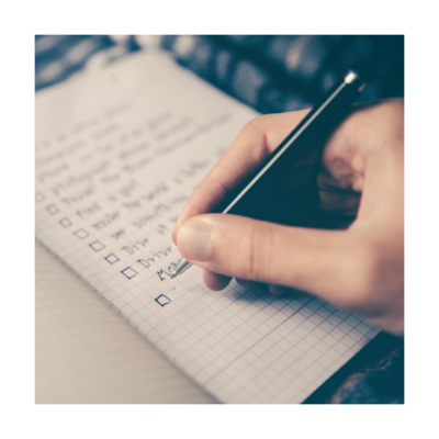 closeup of hand writing a check list