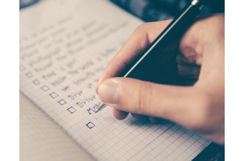 closeup of hand writing a check list